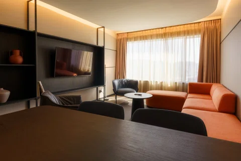 Living de habitación con sofá naranja y televisor.