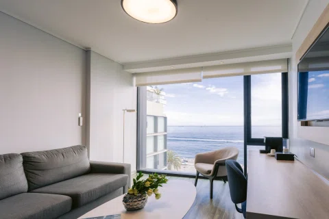 Living de suite con sofá y vista directa al mar.