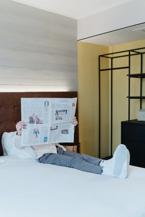 Maleta abierta sobre cama junto a objetos personales.