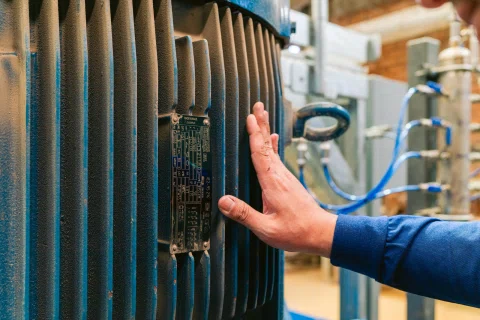 Mano inspeccionando aletas de motor eléctrico.