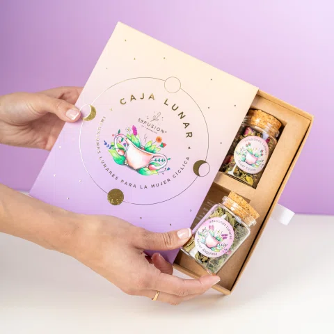 Manos abriendo caja de regalo Caja Luna con productos.