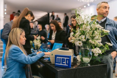 Mesa de acreditación recibe asistentes en un evento corporativo.