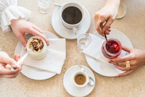 Mesa compartida con postres café y salsas.