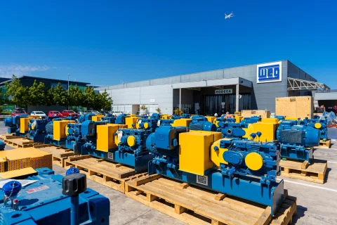 Motores industriales azules y amarillos frente a planta WEG.