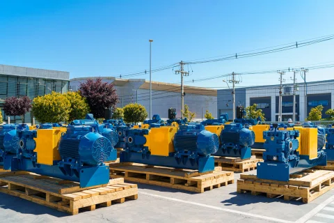 Motores industriales preparados sobre pallets en el exterior de una planta.