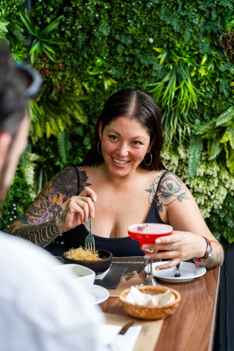 Mujer comiendo en terraza del restaurante.