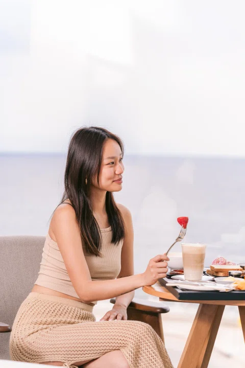 Mujer sentada frente a mesa con cóctel.