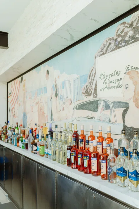 Mural ilustrado sobre barra con botellas.