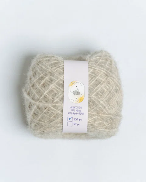 Ovillo de lana gris claro con etiqueta de producto.