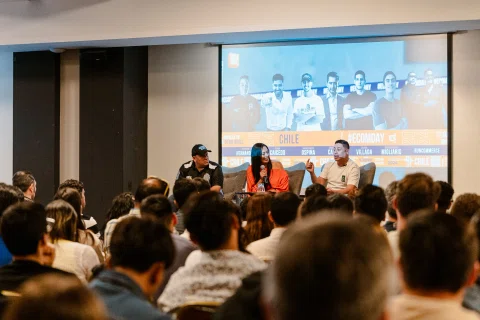 Panel de conversación en escenario frente a una audiencia.