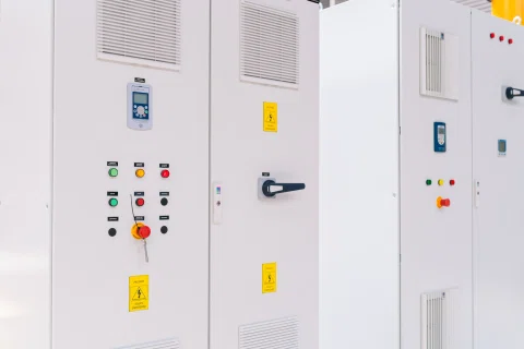 Paneles eléctricos blancos con controles y señalización.