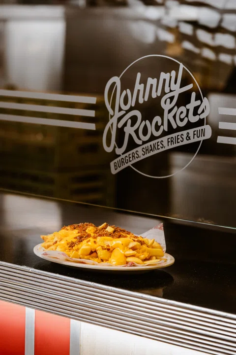 Papas con queso servidas en una barra de Johnny Rockets.