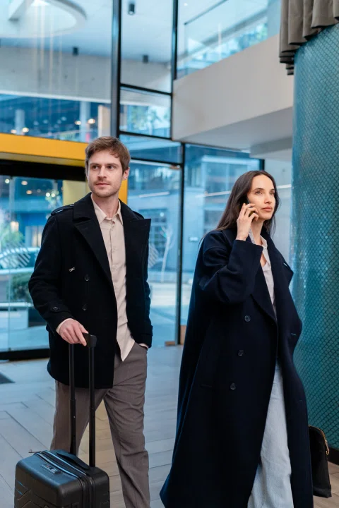 Pareja caminando con equipaje por el lobby.