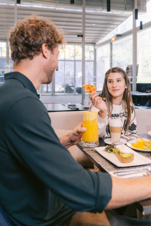 Pareja compartiendo desayuno en restaurante.