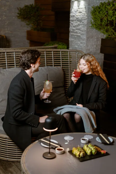 Pareja conversando en terraza nocturna.