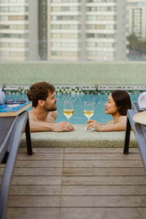 Pareja conversando en terraza con vista urbana.