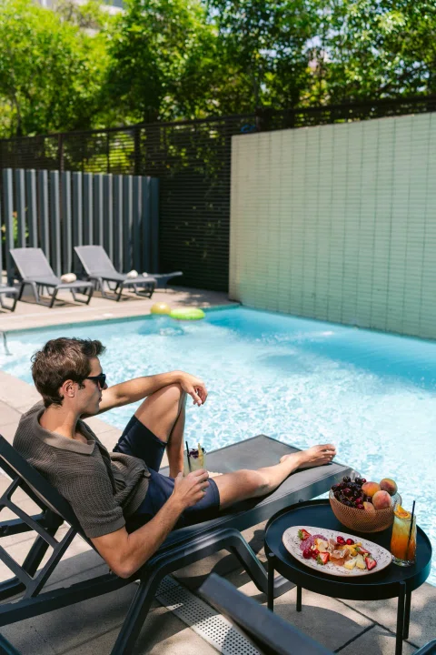 Pareja descansando junto a piscina exterior.