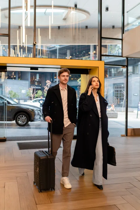 Pareja entrando al lobby del hotel con maleta.