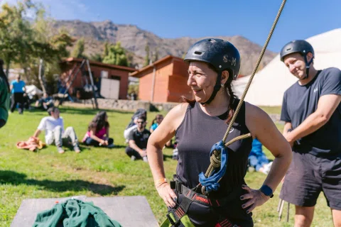 Participante con arnés sonríe durante una actividad de altura.