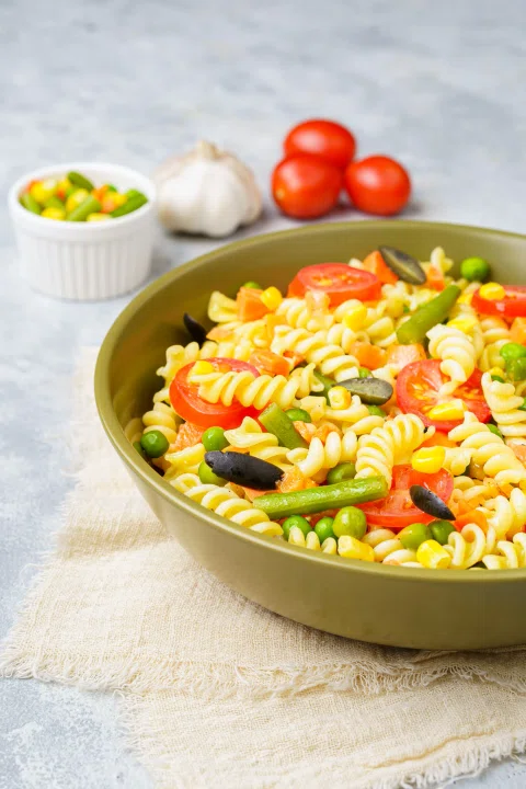 Pasta corta con vegetales en bowl.