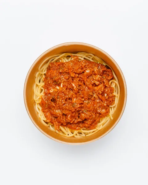 Plato de pasta con salsa de tomate en vista cenital.