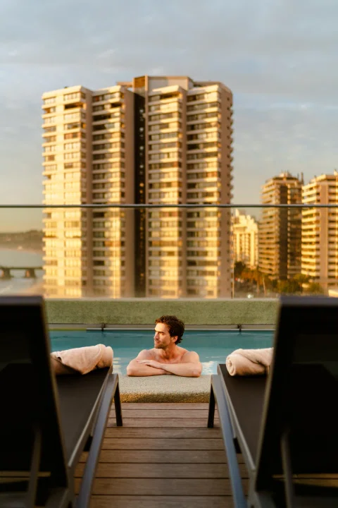 Terraza de hotel con piscina y vista urbana.