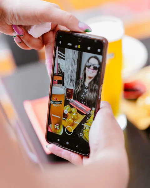Persona fotografiando la mesa con un teléfono.