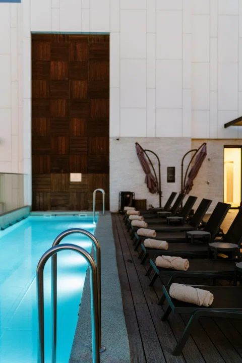 Piscina interior con reposeras alineadas.