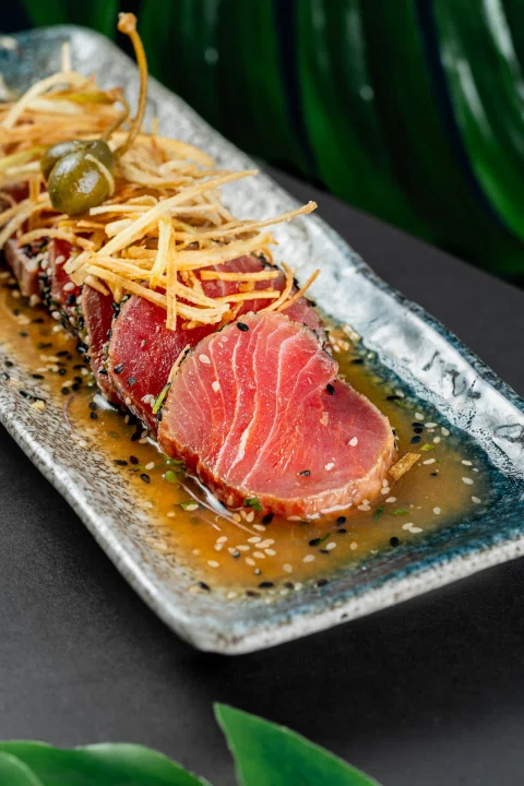 Plato de atún sellado con acompañamientos.