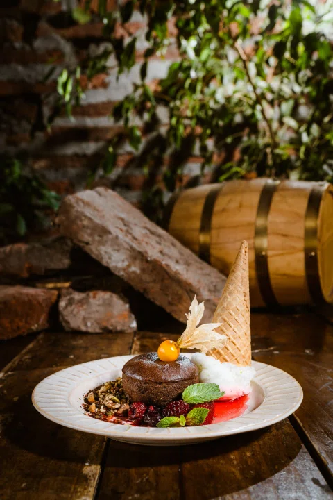 Plato de carne y vegetales presentado con una llama decorativa.