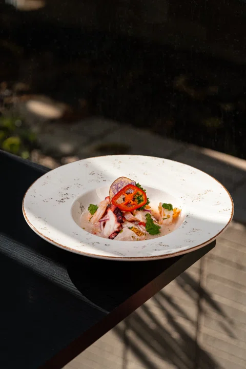 Plato gastronómico aislado en ambiente oscuro.