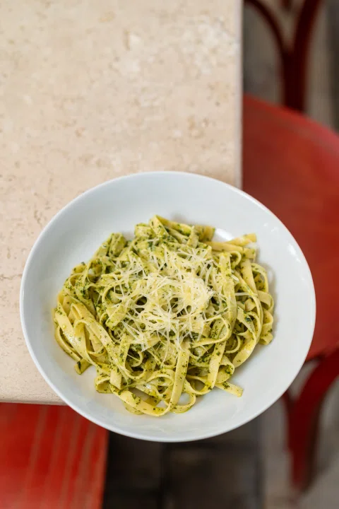 Plato de pasta verde en vista cenital.
