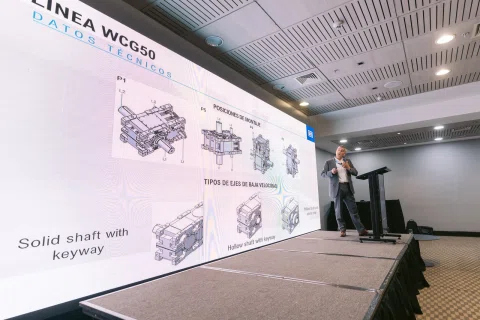 Ponente explica un diagrama de equipos industriales en una pantalla.