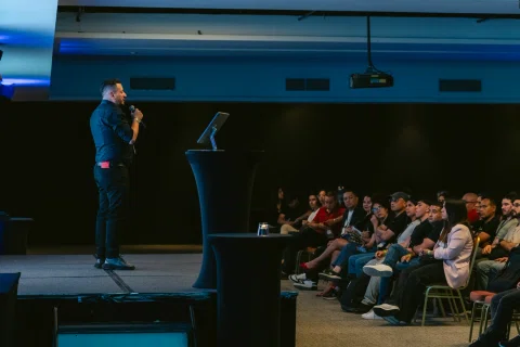 Ponente expone frente al público en una sala de conferencias.