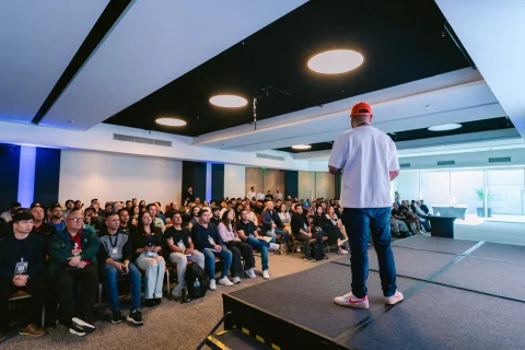 Ponente habla ante una audiencia numerosa en un salón.