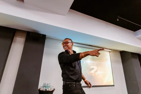 Ponente señala hacia el público durante una presentación.