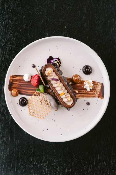 Postre de chocolate y frutas en plato blanco.