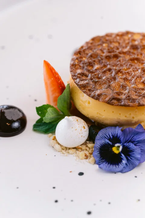 Postre individual con fruta y flor comestible.
