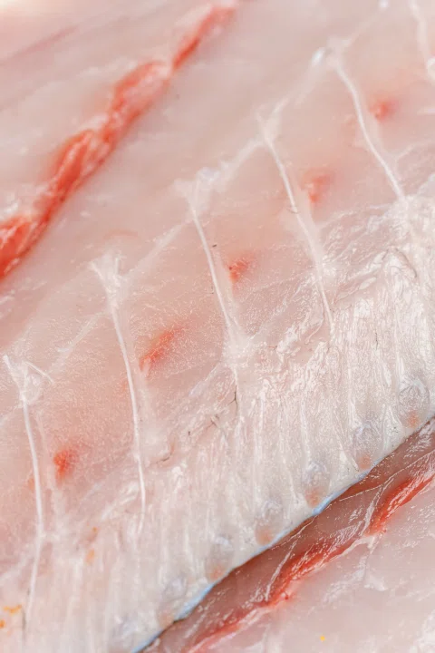 Primer plano de carne de pescado fileteada.
