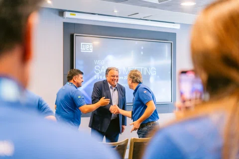 Momento de reconocimiento entre participantes frente a una pantalla.