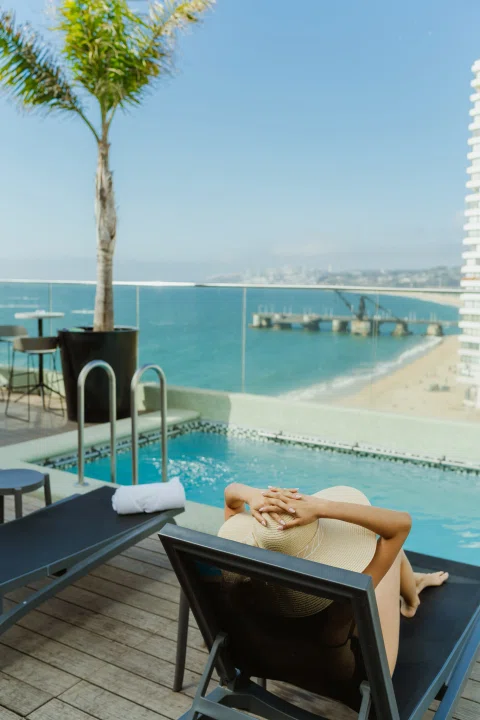 Reposera junto a piscina con vista al mar.