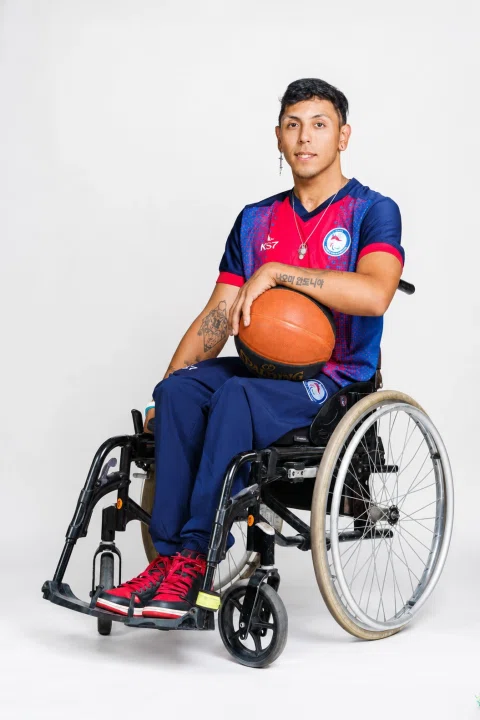 Retrato de un deportista en silla de ruedas con balón.