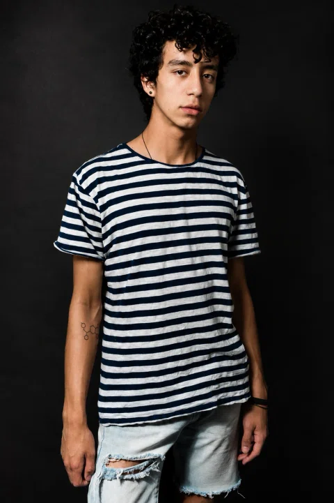 Retrato de un hombre joven con camiseta a rayas.