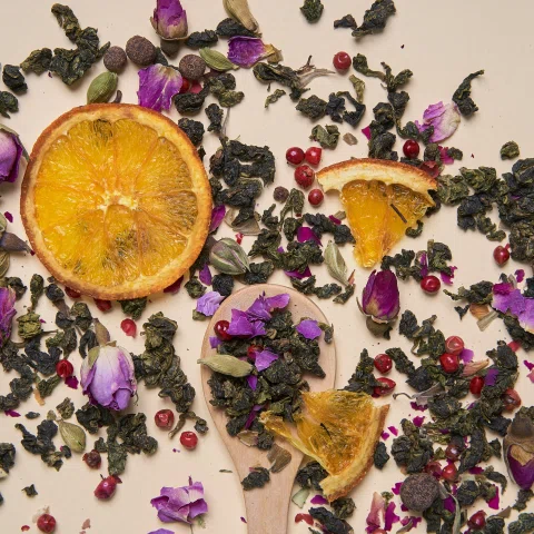 Rodajas de naranja flores y hierbas secas en composición.