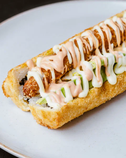 Roll frito alargado con salsa cremosa.