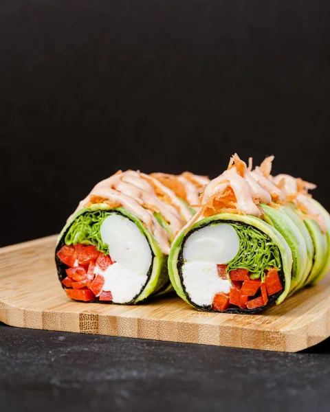 Roll de sushi envuelto en palta con salsa cremosa.