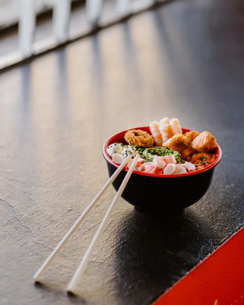 Roll tipo burrito servido en bowl con vegetales.