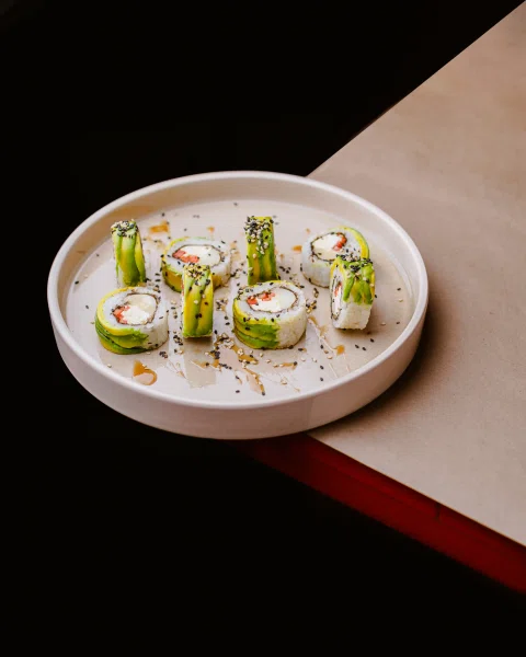 Rolls verdes servidos en plato sobre mesa bicolor.