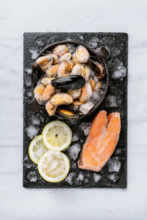 Selección de mariscos y salmón sobre pizarra.
