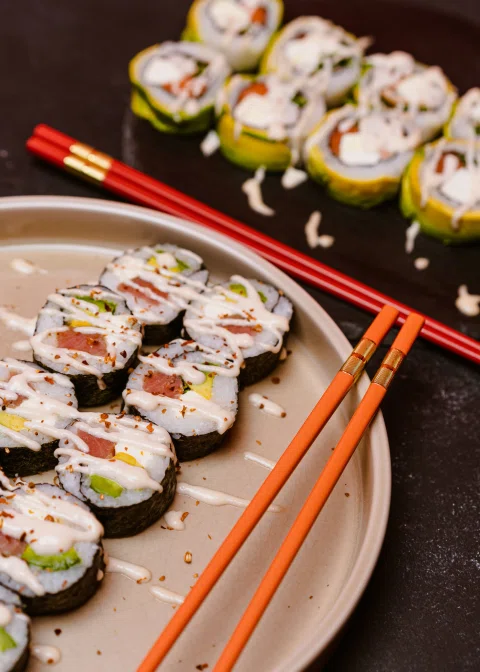 Selección de rolls de sushi con palillos rojos.